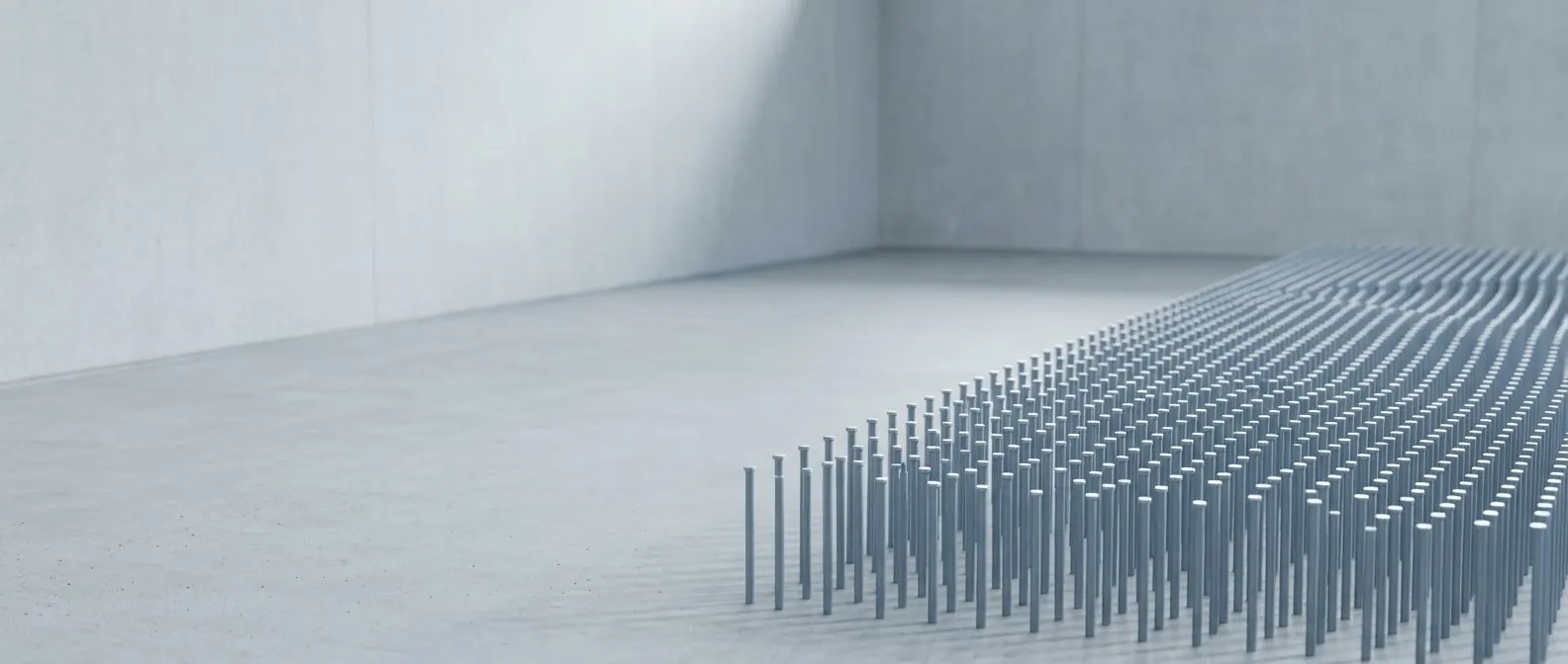 A quiet corner of a concrete gallery where a field of steel pins recedes toward the back wall.